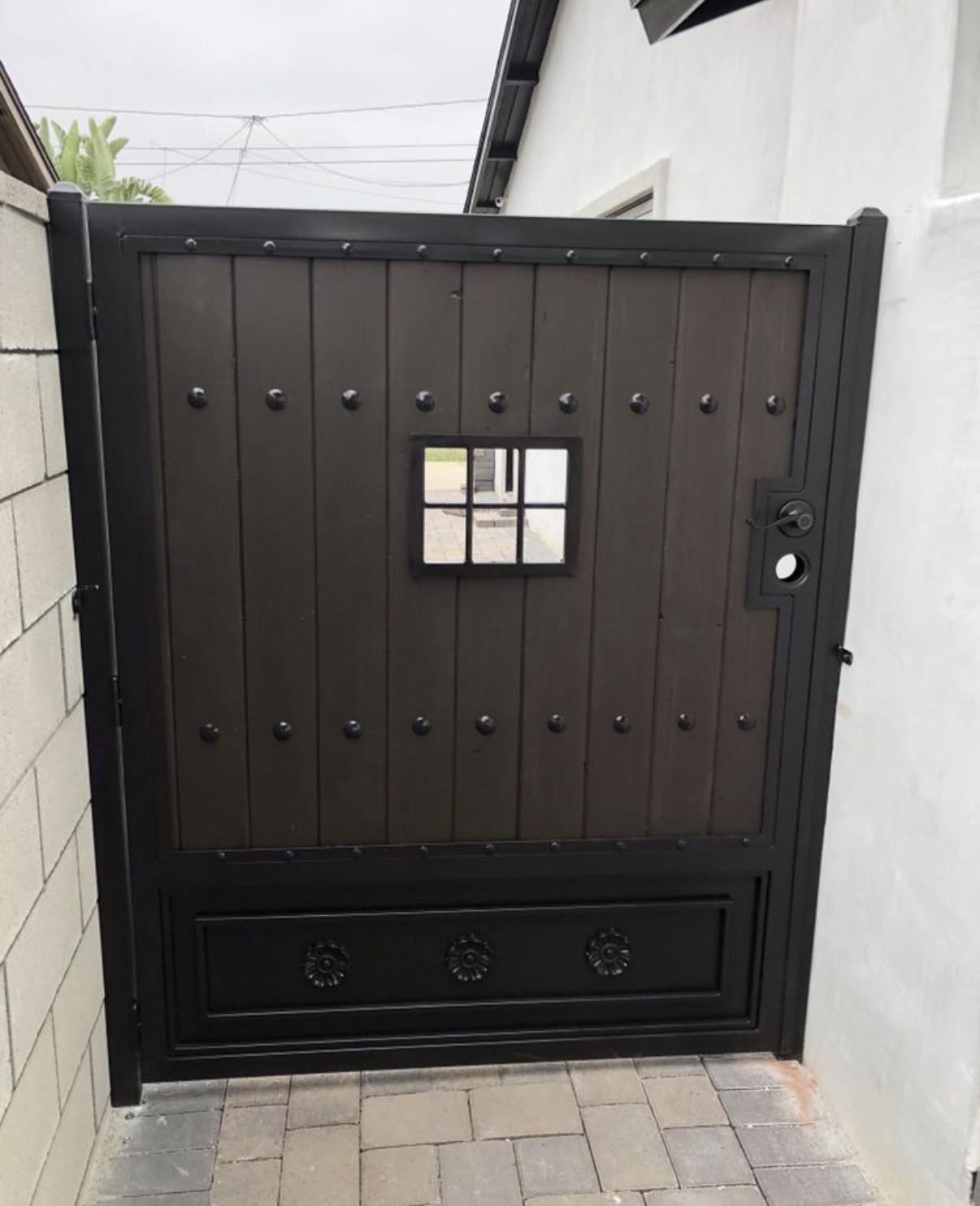 Spanish-style wood gate with iron studs and peep window