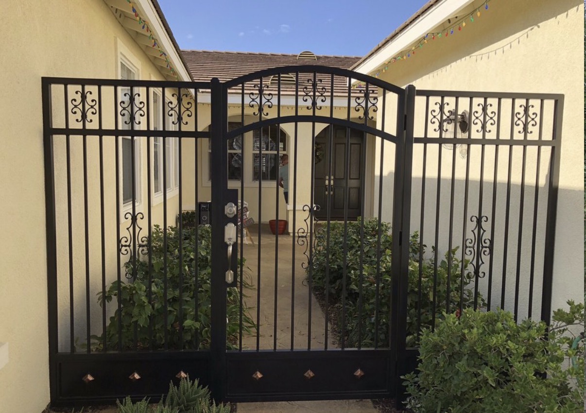 Black iron entry gate with decorative scrollwork
