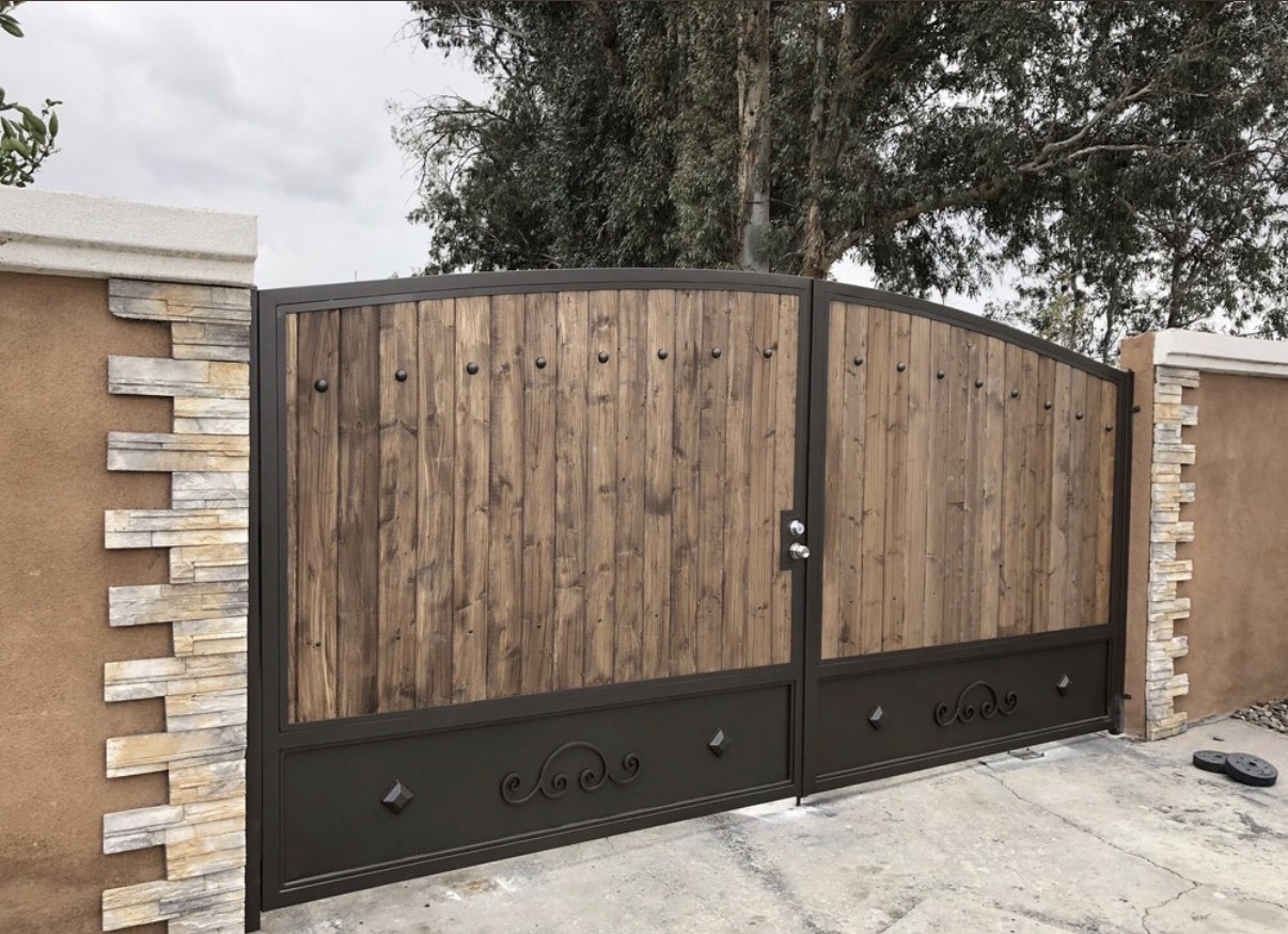 Arched wood driveway gates with iron studs