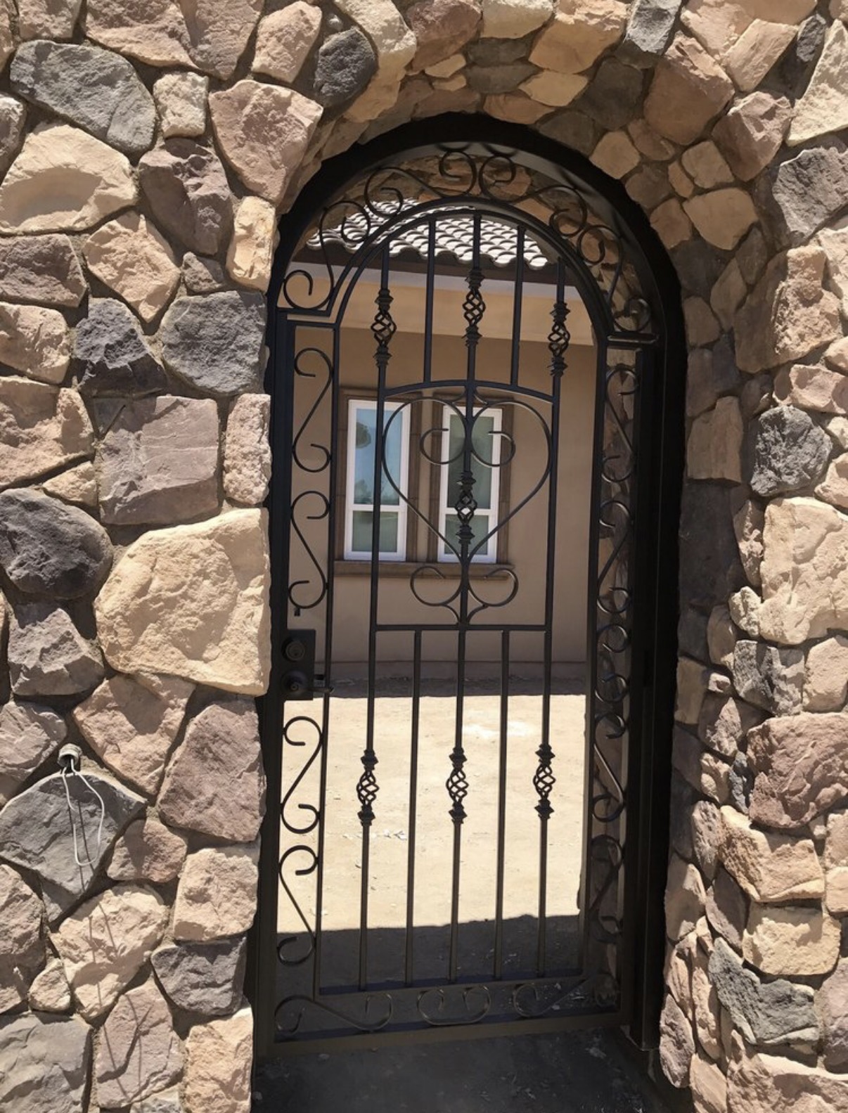 Arched iron gate in stone wall opening