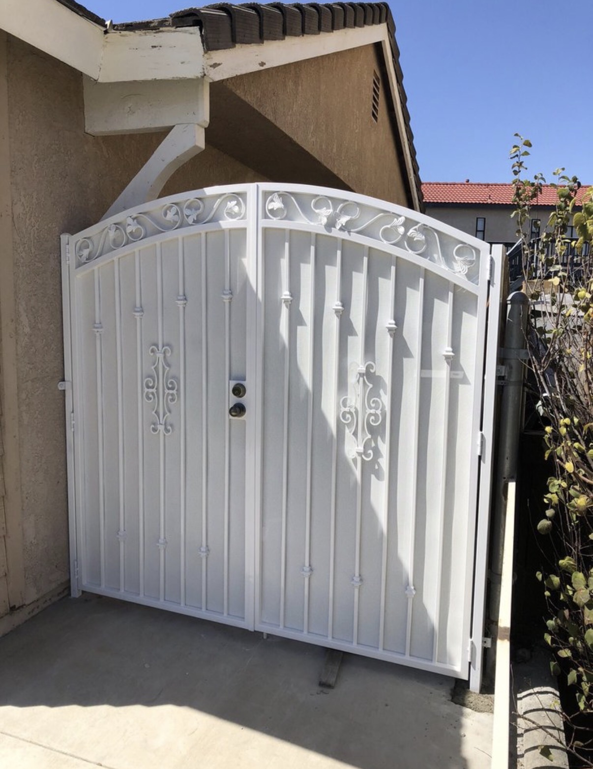 White arched double side gate with decorative scrollwork