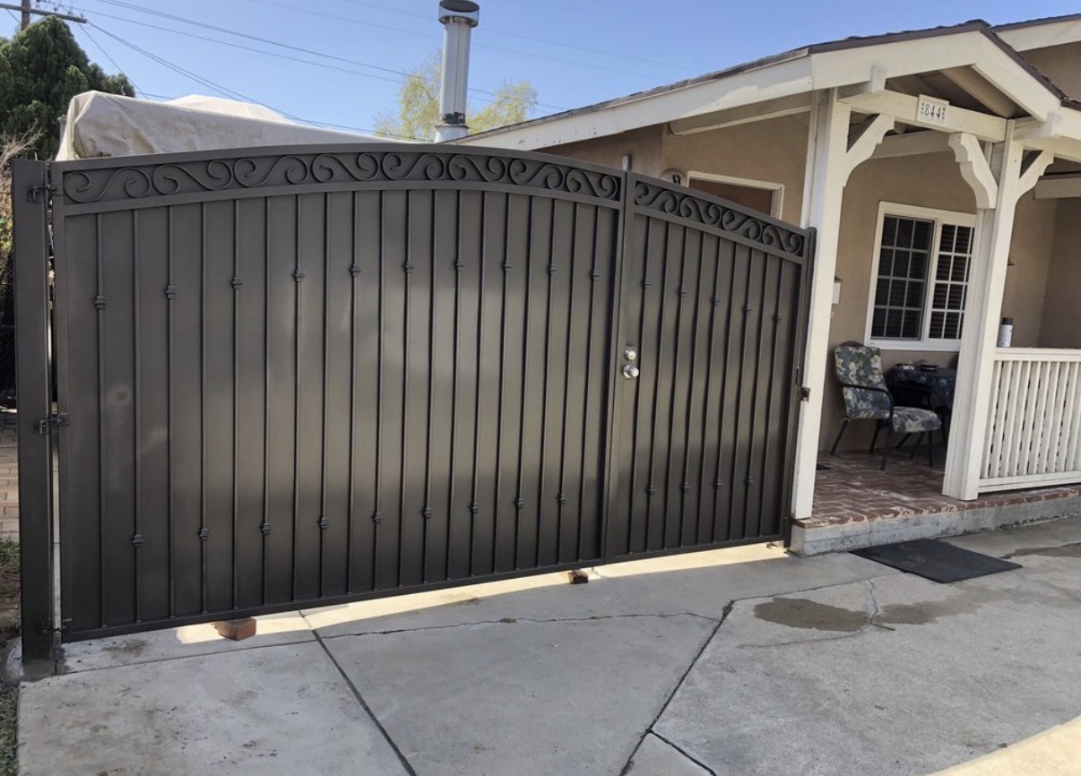 Bronze arched driveway gate with scrollwork top