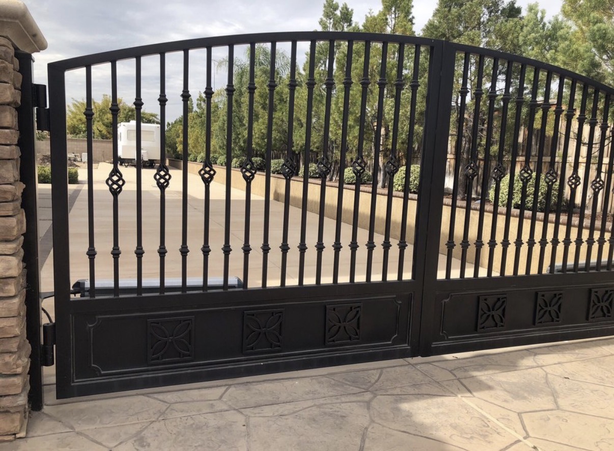 Black iron driveway gates with basket twist accents