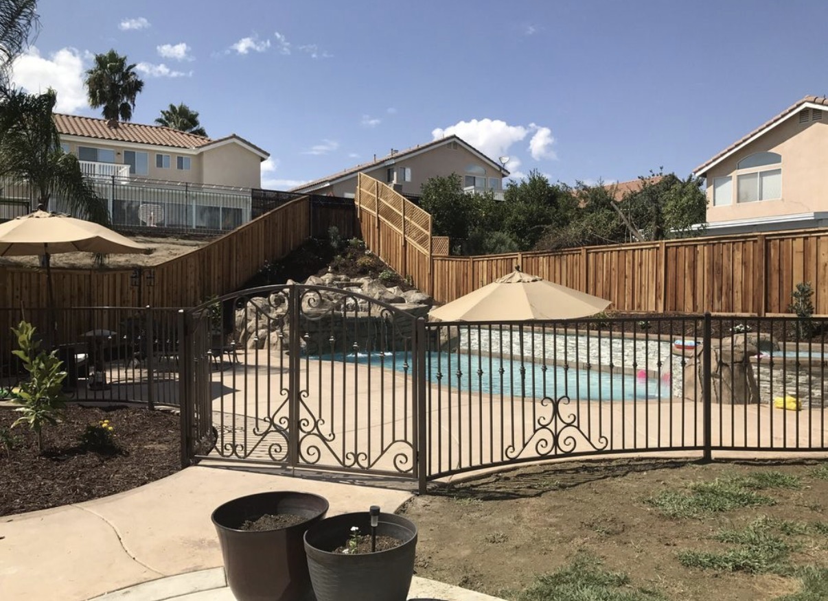 Bronze iron pool fence with scrollwork backyard view