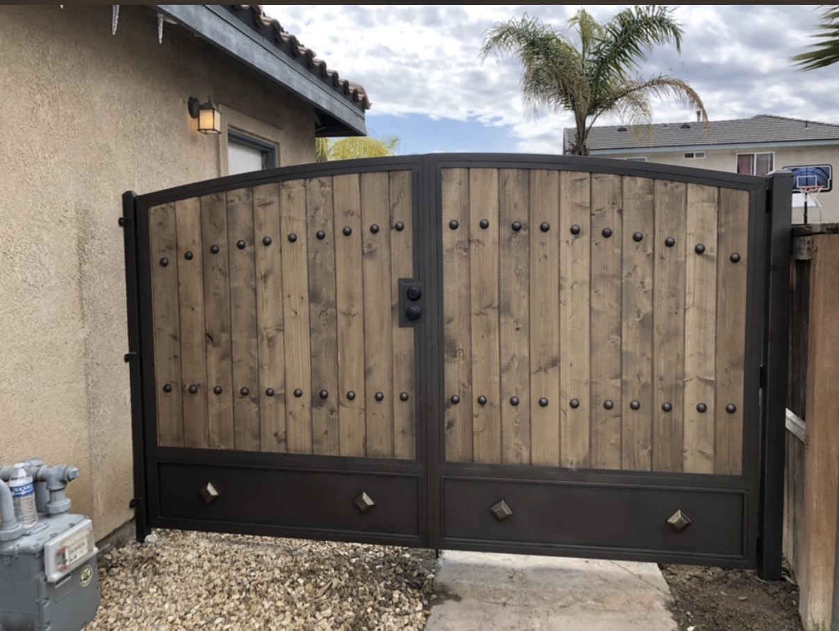 Wood and iron arched double driveway gate with studs
