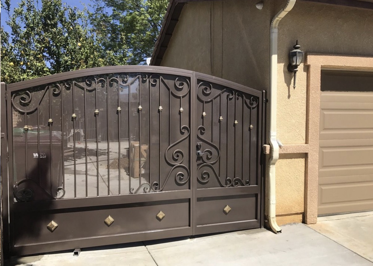 Bronze iron driveway gate with scrollwork and diamond accents