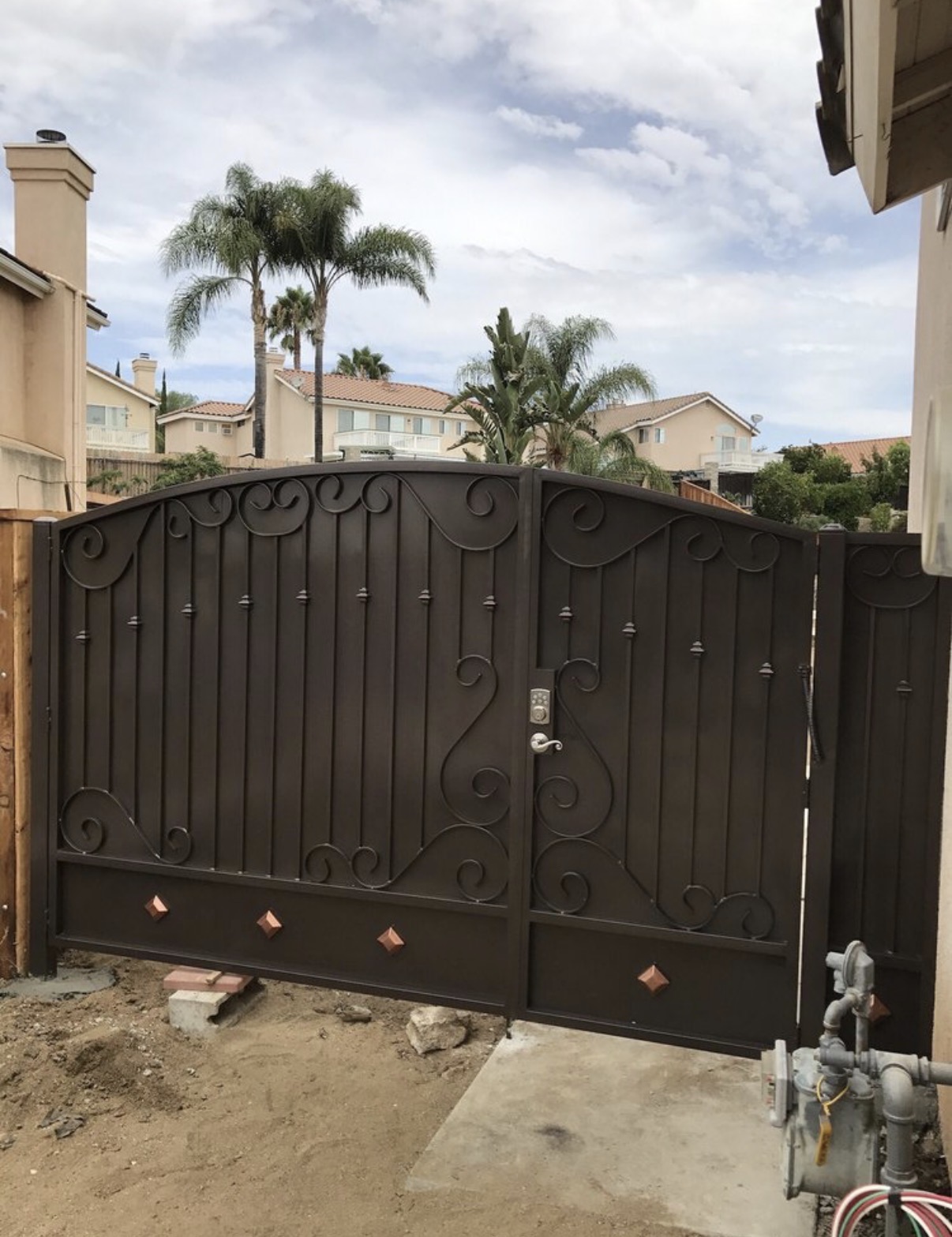 Bronze iron arched driveway gate with copper diamond accents