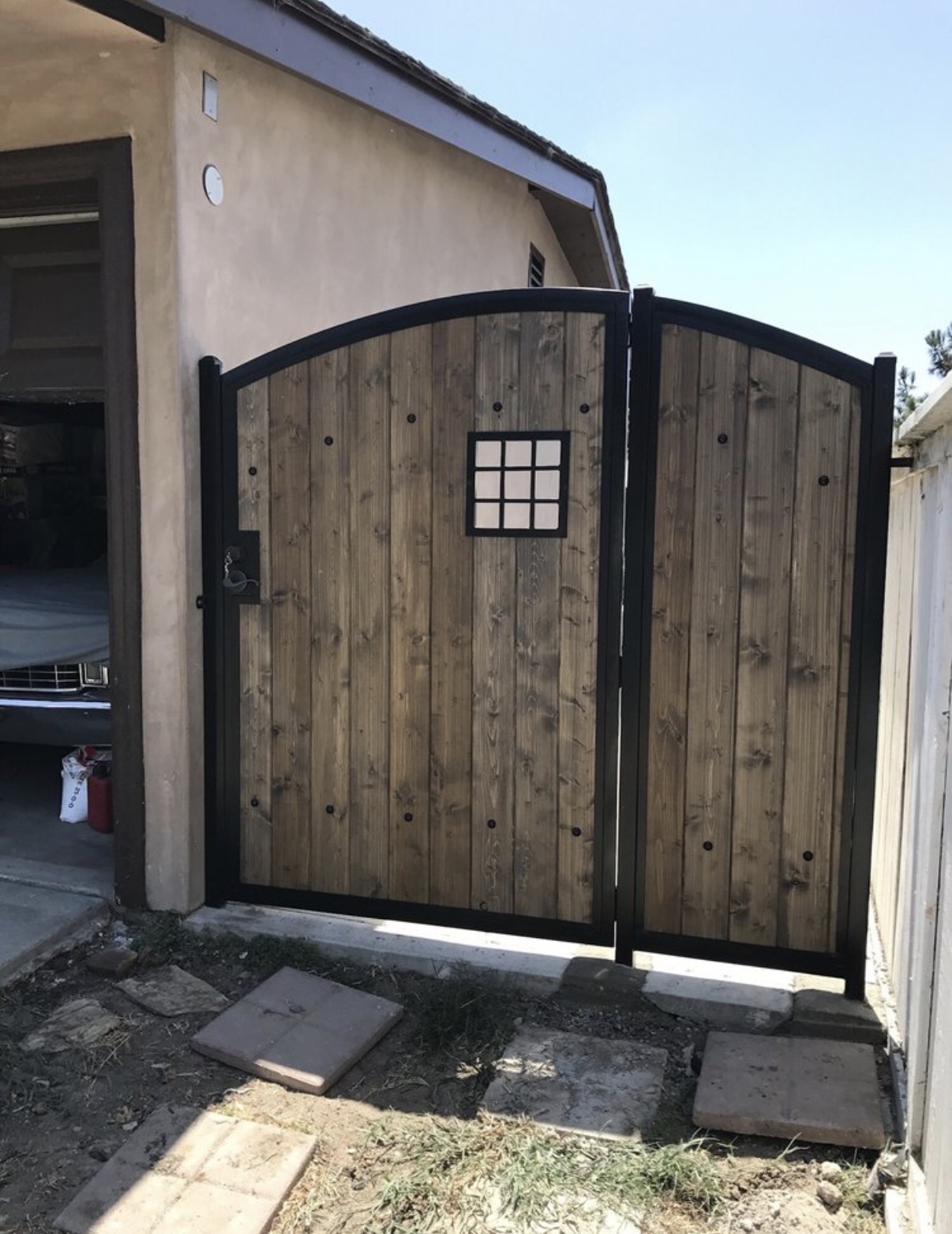 Wood and iron arched double gate with window detail