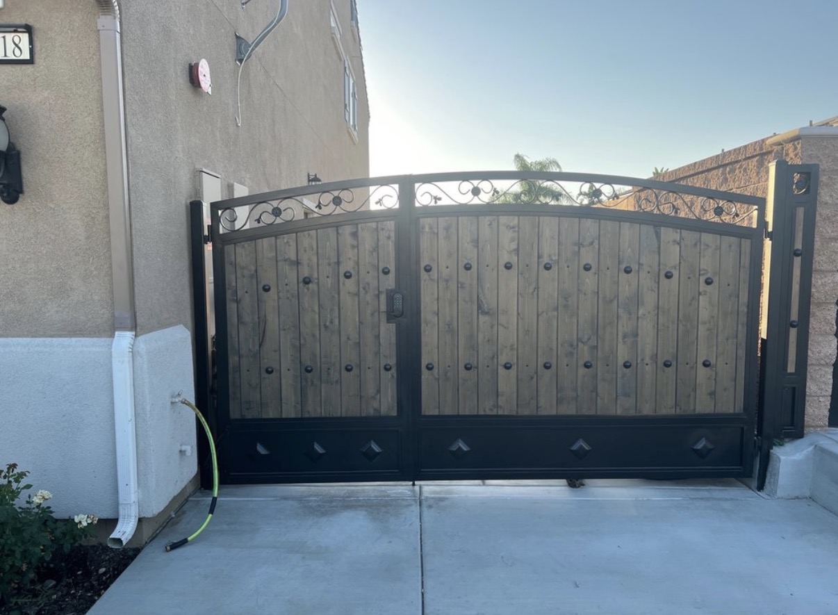 Wood and iron arched driveway gate with diamond accents and keypad