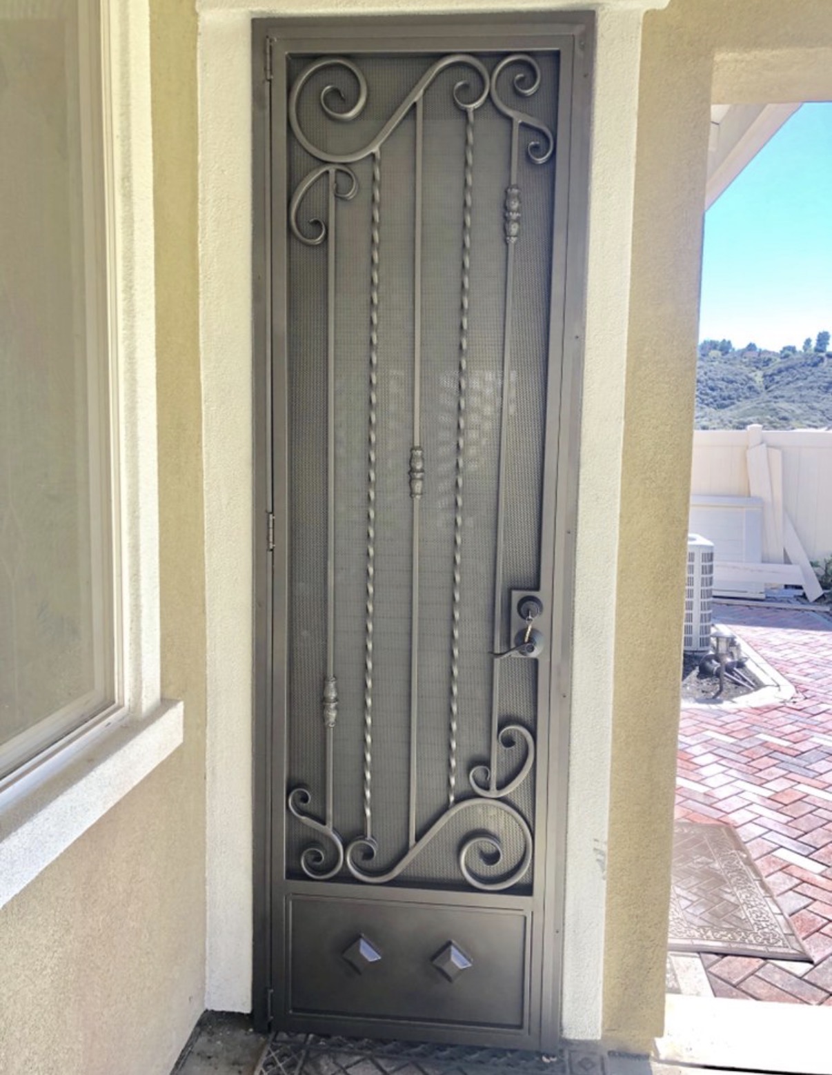 Custom iron security screen door with scrollwork